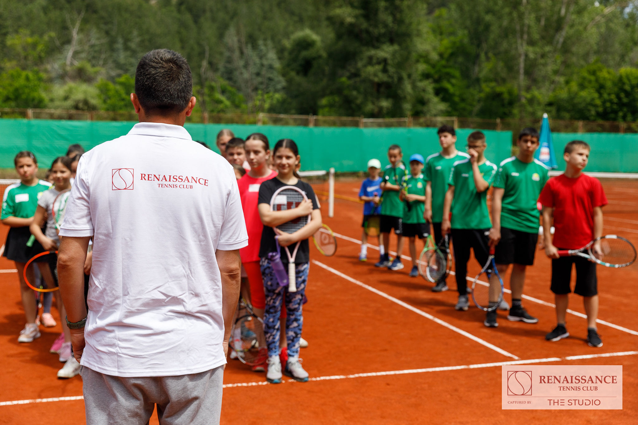 Треньор от Ренесанс с група деца на тенис корта